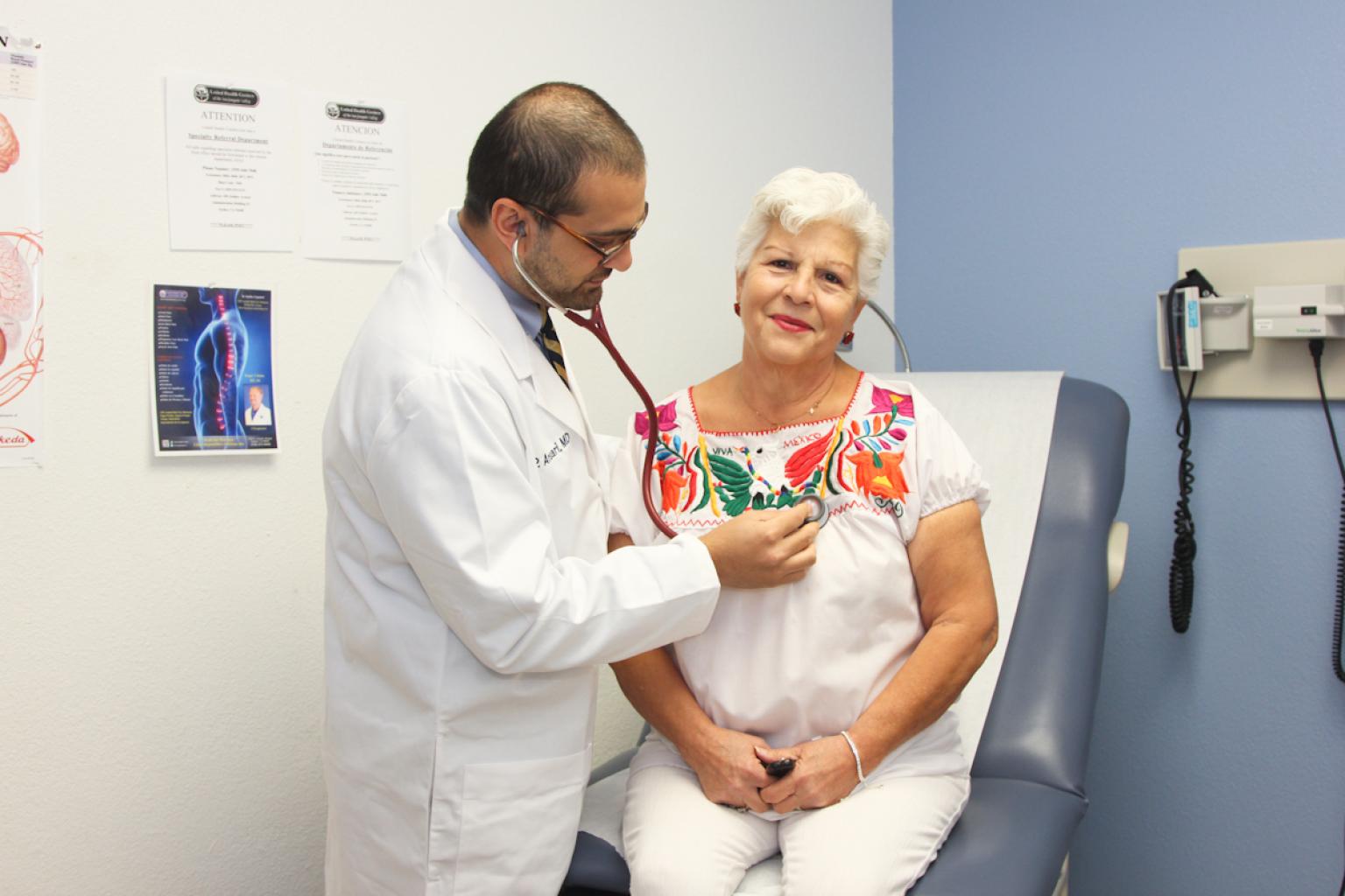 Doctor using stethoscope on patient